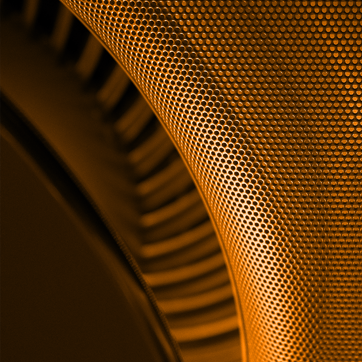 close-up of a metallic, perforated cylindrical surface with a warm orange tint, showcasing detailed texture and curved lines